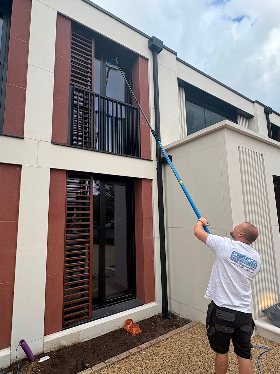 S&J Exterior Cleaning pole-fed window cleaning on a modern home